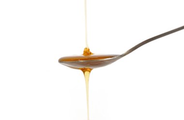 Beyaz arka planda izole edilmiş bir kaşıkla bal. Çok tatlı. Yiyecekler. Bal arıları ve balmumu. Nektar.