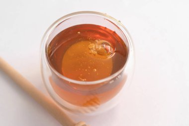 Beyaz arka planda izole edilmiş tahta çubuklu bal. Tatlı yemek. Bal arıları ve balmumu. Nektar.