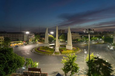 Demokrasi abidesinin havadan görünüşü, bir döner kavşak, Bangkok şehir merkezi ufuk çizgisinde arabalarla dolu bir sokak yolu, gün batımında kentsel şehir, Tayland. Şehir simgesi mimari manzarası.