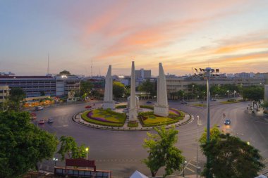 Demokrasi abidesinin havadan görünüşü, bir döner kavşak, Bangkok şehir merkezi ufuk çizgisinde arabalarla dolu bir sokak yolu, gün batımında kentsel şehir, Tayland. Şehir simgesi mimari manzarası.