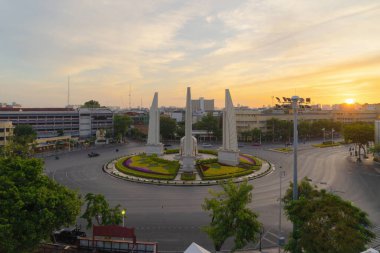 Demokrasi abidesinin havadan görünüşü, bir döner kavşak, Bangkok şehir merkezi ufuk çizgisinde arabalarla dolu bir sokak yolu, gün batımında kentsel şehir, Tayland. Şehir simgesi mimari manzarası.
