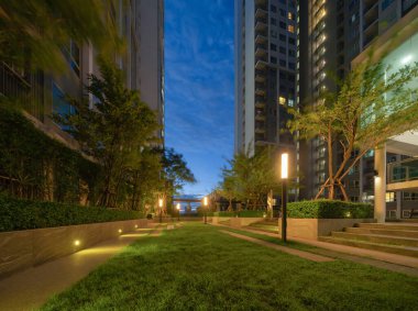 Gökyüzü parkı, özel çatı katı ya da otel bahçesi, geceleri ağaç, çimen tarlası ve mavi gökyüzü olan yüksek binalar..