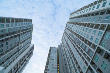 Yüksek binalara, gökdelenlere, mavi gökyüzü olan finans bölgesindeki mimarilere bakıyorum. Şehir merkezinde iş ve teknoloji konsepti için akıllı şehir.