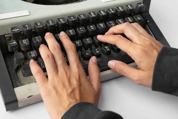 People hands typing an old Thai traditional typewriter. Classic vintage antique manual typing machine isolated on white background. 19th century item. Lifestyle