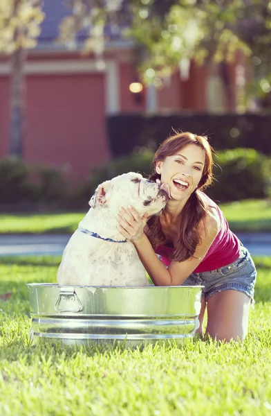 Belle femme lavant son chien de compagnie dans une baignoire — Photo