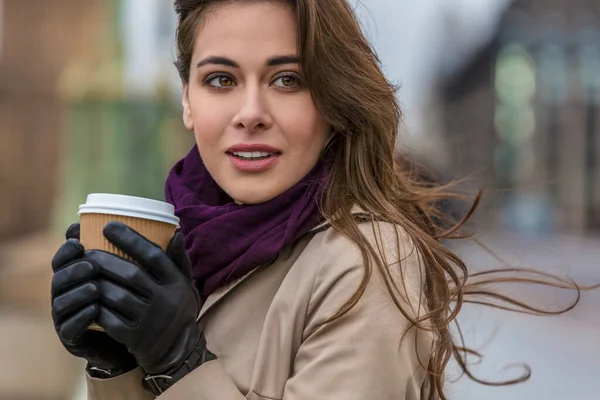 在寒冷潮湿天气下 穿着手套 围巾和雨衣 在户外的一次性杯子里喝咖啡或喝茶的女孩或年轻妇女 — 图库照片