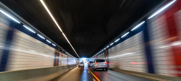 全景网页横幅运动模糊了在隧道全景中的湿路上交通和车辆的照片 — 图库照片