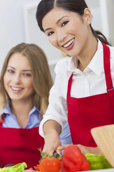 Woman and her friend cutting vegetable salad — Stock Photo, Image