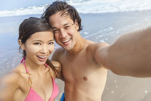 Asijský pár na pláži s selfie fotografie — Stock fotografie
