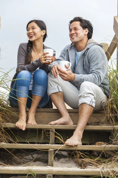 Asiatisch mann frau paar trinken kaffee strand steps — Stockfoto