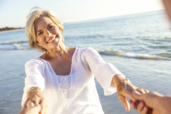 Lyckliga äldre par promenader anläggning händer tropisk strand Stockbild