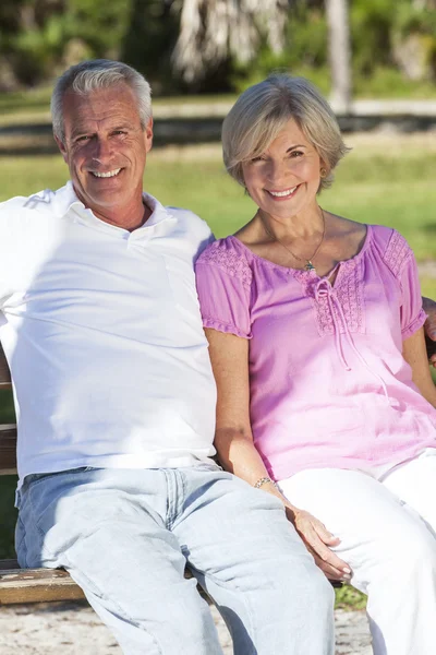 Heureux couple âgé assis sur le banc au soleil — Photo