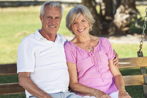 Gelukkige Senior paar zittend op de Bank in de zon — Stockfoto