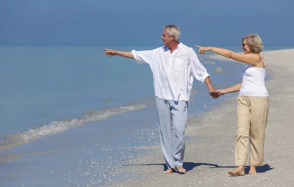 Mutlu üst düzey çift işaret tutan eller Beach yürüme — Stok fotoğraf