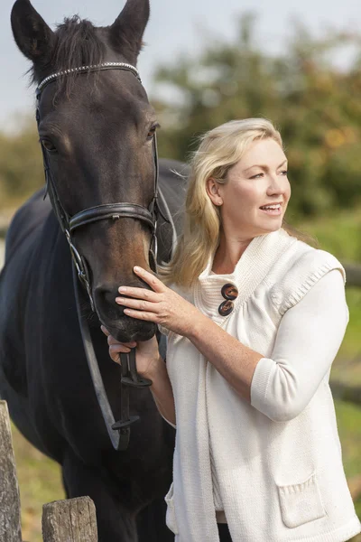 Middle Aged vrouw streelde haar paard — Stockfoto