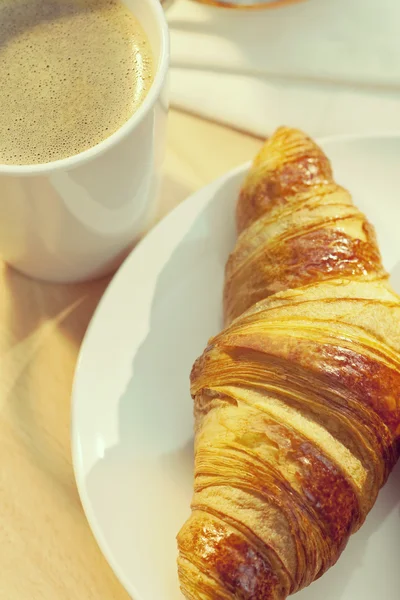 Continentaal ontbijt croissant en kopje koffie — Stockfoto