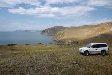Ovada deniz manzaralı beyaz bir off-road arabası.