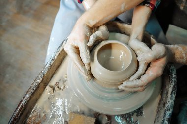 Kil tenceresi yapan iki el. Çömlek atölyesinde buluşalım. Resmi yaklaştır.