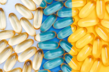 Üç renkli arka planda haplar. Şeffaf haplar. Beyaz, mavi ve sarı arkaplan.