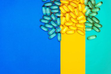 Üç renkli parlak arkaplanda haplar. Mavi, sarı, turkuaz arka plan. İlaçlar. Sağlık Hizmetleri.