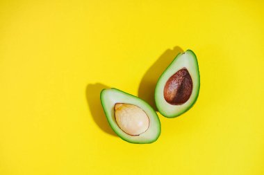 Sarı arka planda dilimlenmiş avokado. Düz yatıyordu. Üst Manzara. Parlak resim