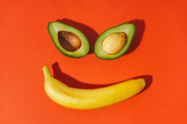 Avokado ve muzdan yapılmış gülen surat. Uzaylı suratı. Yüzü meyveden yapılmış. Sağlıklı yaşam tarzı kavramı.