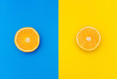 Renkli bir arkaplanda bir portakalın iki yarısı. Mavi ve sarı arkaplan