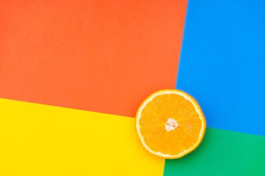 Renkli bir arkaplandaki portakalın yakın plan fotoğrafı. Birden fazla parlak renk. Üst görünüm.