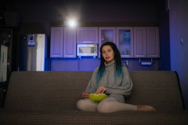 Evde rastalı bir kız projektör filmi izliyor.