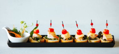 Karides ve kiraz domatesli beyaz ekmek kanepeleri.