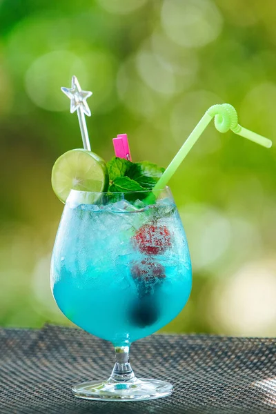 Blue cocktail with lime, cherries, mint and straw — Stock Photo, Image