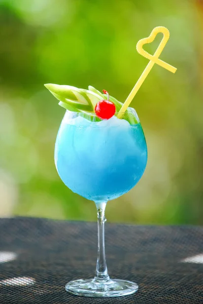 Blauwe cocktail met appel, kers en geel stro — Stockfoto