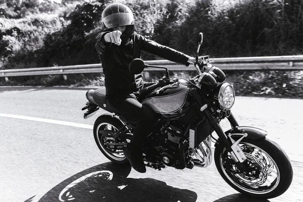 Motociclista monta su motocicleta y apunta a la cámara —  Fotos de Stock