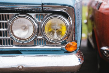Mavi bir eski arabanın ön ışıkları.