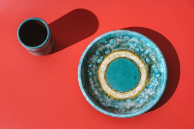 Kırmızı arka planda bir kupa seramik plaka