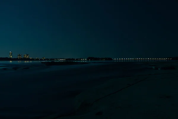 Nagyvárosi fények éjszaka víz felett — Stock Fotó