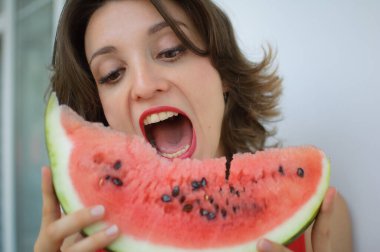 Kapalı alanda, kısa saçlı ve karpuz yiyen şehvetli dudaklı güzel bir kadının portresi. Hedonizm, mutluluk ve yüzme