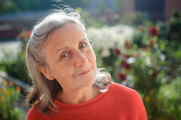 Portrait of a mature woman with grey hair spending time outdoors during sunny day, happy retirement — Stock Photo, Image