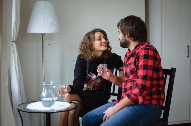 Lambersex tarzı giyinmiş yakışıklı sakallı adam Sevgililer Günü kutlamasında siyah elbiseli genç kadınına sarılıyor.