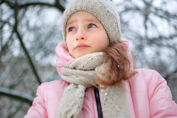 Küçük üzgün kız parkta pembe kıyafetler giyip ağlıyor. Mutsuz çocuk soğuk kış boyunca dışarıda zaman geçirirken donmuş. — Stok fotoğraf