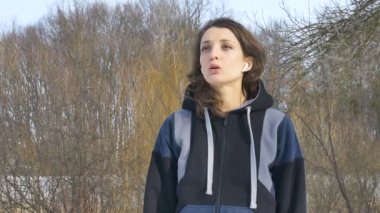 Genç atletik kızın bahar portresi. Parkta sabah egzersiz yaparken. Koyu renk spor giysisiyle. Sağlıklı yaşam tarzı kavramı.