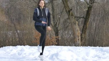 Ukrayna, Lviv, 21 Şubat 2021 - Parkta spor kıyafetiyle egzersiz yapan genç bir kızın bahar portresi. Sağlıklı yaşam tarzı kavramı.