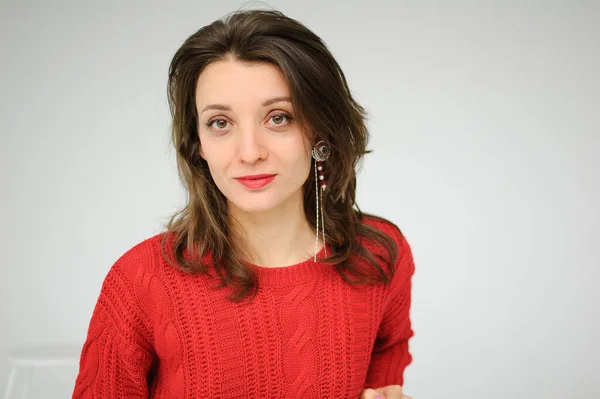 Studio ritratto di giovane donna in maglia rossa maglione e orecchino su sfondo bianco — Foto Stock