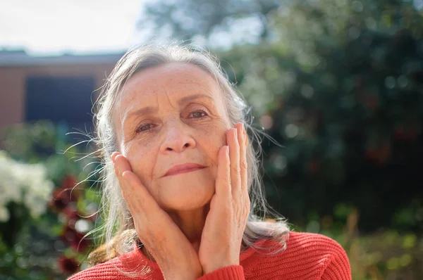 Portret van een volwassen vrouw met grijs haar tijd doorbrengen buiten tijdens zonnige dag, gelukkig pensioen — Stockfoto