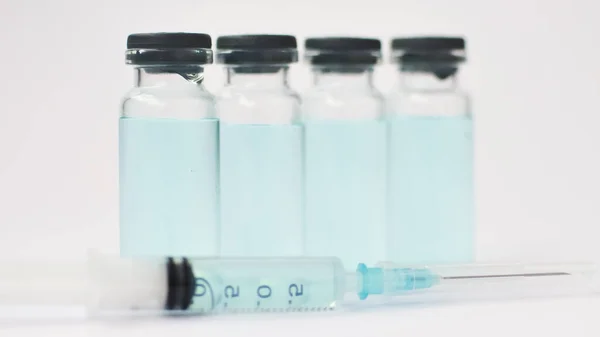Медицинские ампулы и шприц с инсулином на белом фоне, концепция вакцинации — стоковое фото