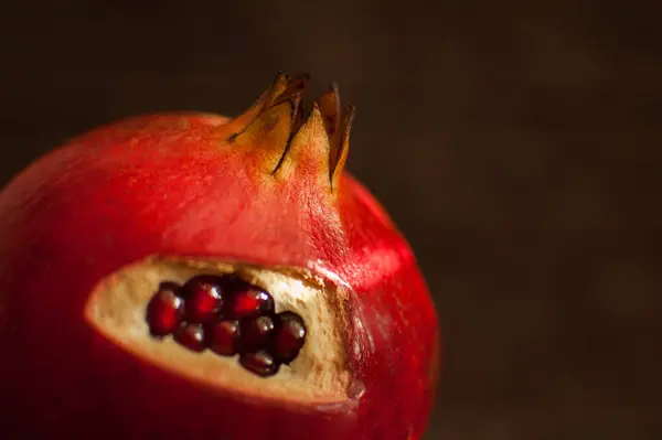 Saftiger Granat, reife Granatapfelfrüchte auf hölzernem Hintergrund. — Stockfoto