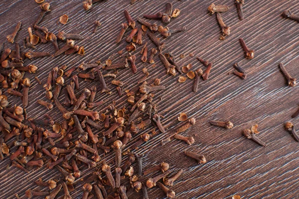 Close up of cloves on old wooden table with empty space for text. — Stock Photo, Image