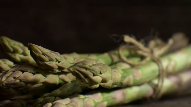 Stelletje verse groene asperges op donkere houten tafel, gezond eten, seizoensproducten — Stockvideo