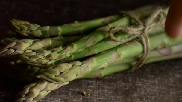 Sekelompok asparagus hijau segar di atas meja kayu yang gelap, makanan sehat, produk musiman — Stok Video