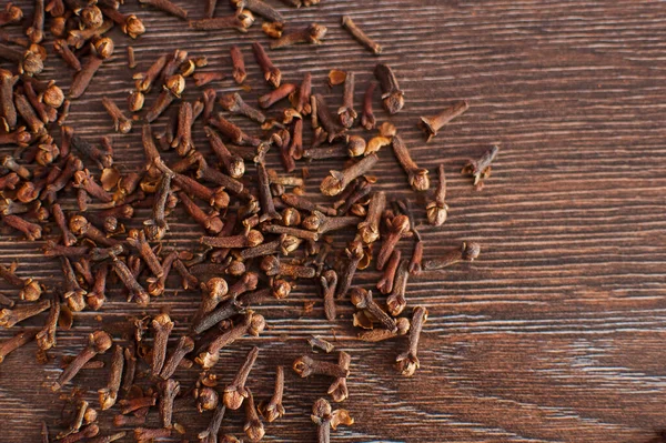 Close up of cloves on old wooden table with empty space for text. — Stock Photo, Image